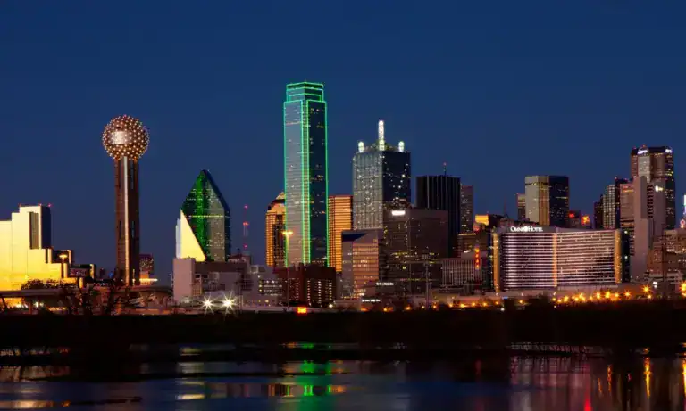 The Dallas skyline at dusk, Reunion Tower on the left, reflected in the Trinity River